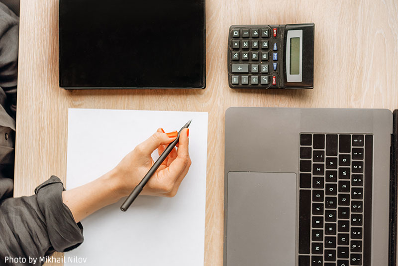 838 woman holding pen with paper calculator and laptop 